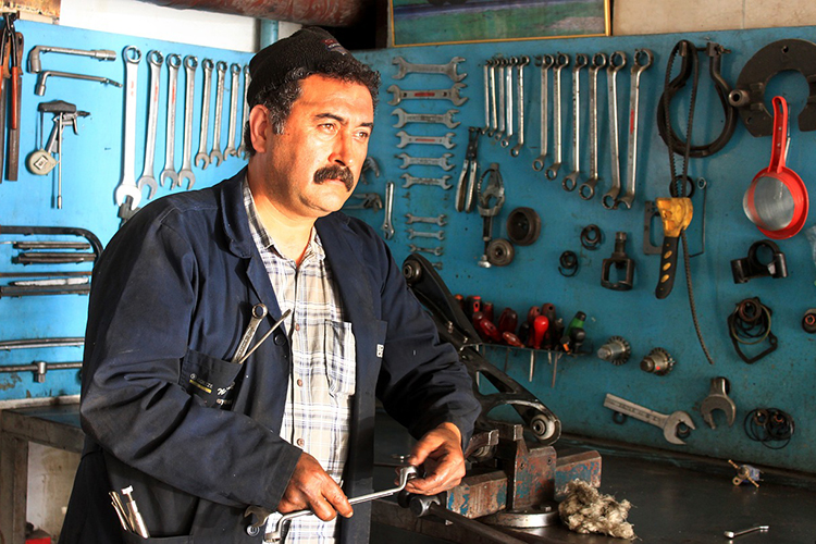 man looking into the distance surrounded by tools