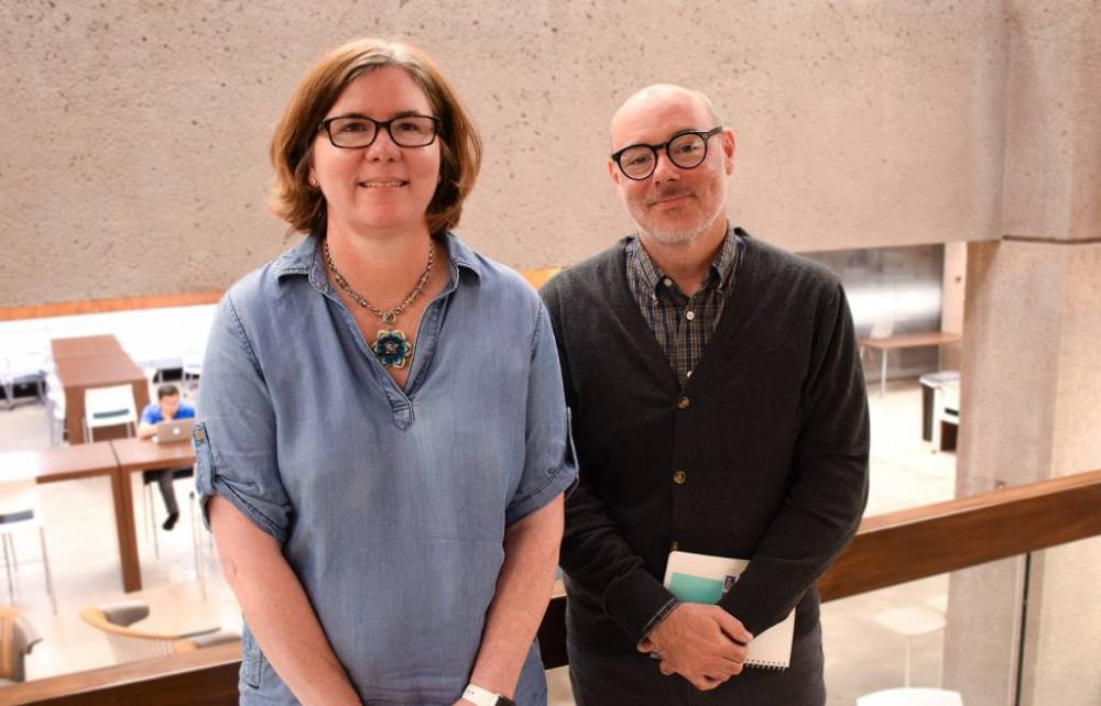 woman and man standing in a library