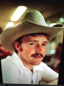 Portrait of Mike Combs wearing a cowboy hat in 1985