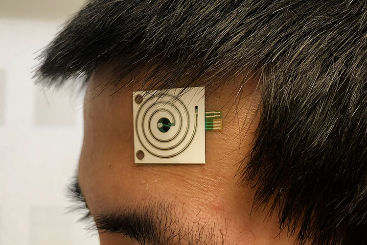 A close up shot of a new sweat sensor on a person's forehead