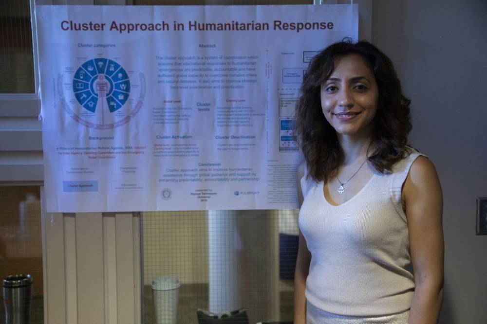 woman standing in front of poster