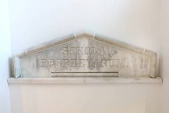 Divinity School renovation - Schola Propheterum pediment The historic stone pediment engraved with the Latin term “schola prophetarum,” or “school of prophets," was salvaged and is prominently featured in the main stairwell. (Anne Rayner/Vanderbilt)