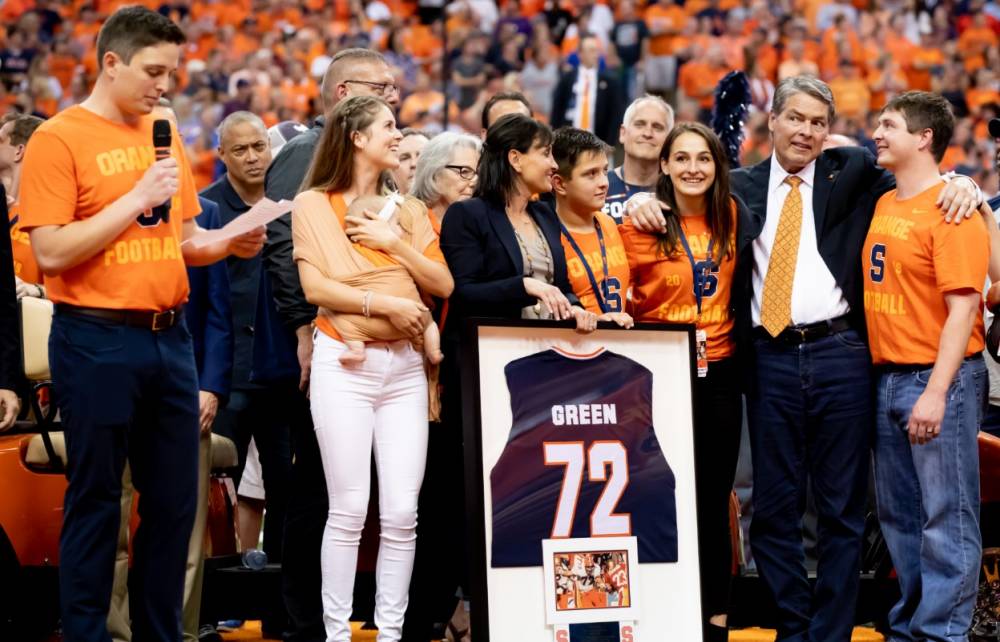 man is honored surrounded by family and friends on football field