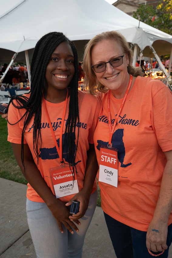 two women standing in front of a tent