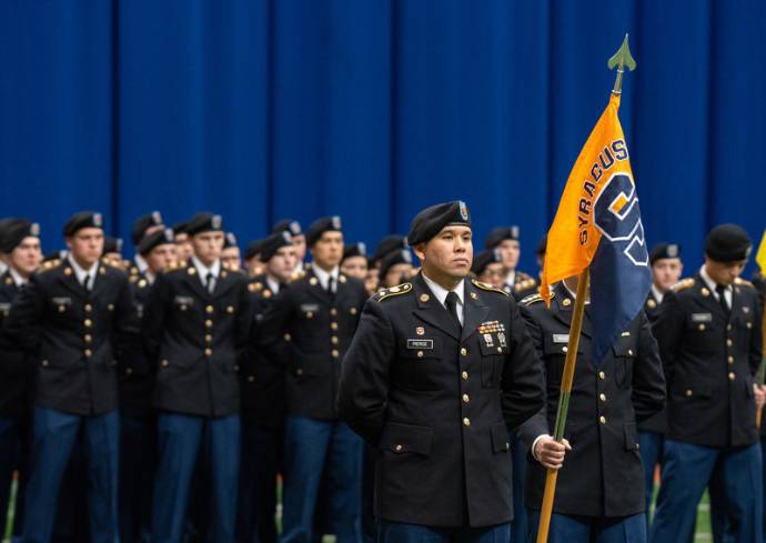 military service members stand with flag