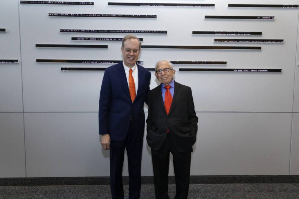 Two men standing in front of a wall