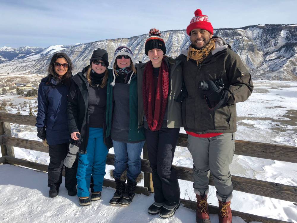 Graduate students and professor standing in snow