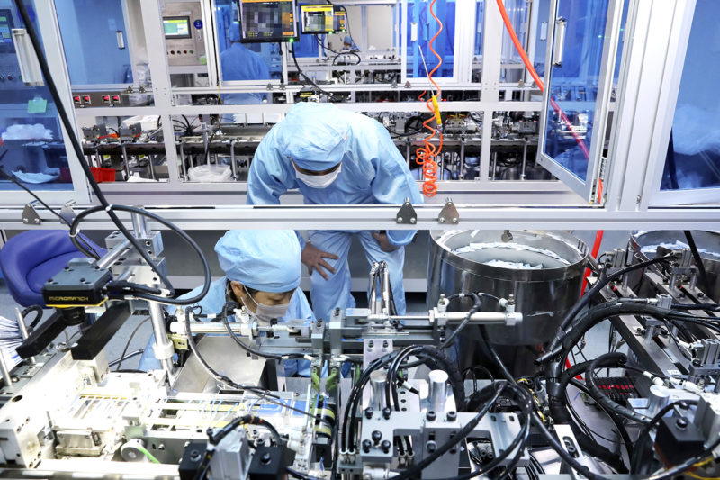 People work on the production line of SARS-CoV-2 testing kits in a biopharmaceutical company in Nantong city in east China's Jiangsu province Monday, March 09, 2020. (FeatureChina via AP Images)