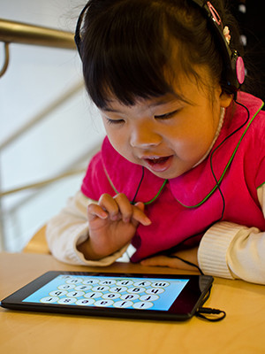 Young girl playing on a tablet